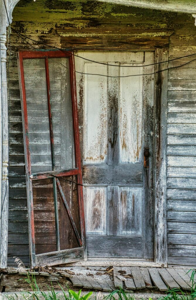 An aged and weathered door of an abandoned house conveys rustic charm.